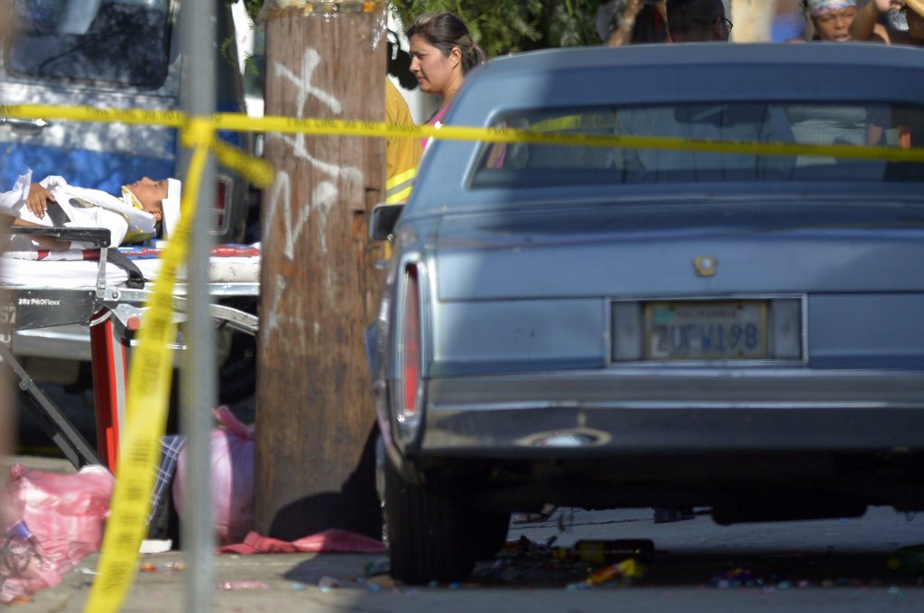 A young victim, left, is transported by Los Angeles city firefighters after police say a car driven by a 100-year-old went onto a sidewalk and plowed into a group of parents and children outside a South Los Angeles elementary school, Wednesday, Aug. 29, 2012, in Los Angeles. Nine children and two adults were injured in the wreck. (AP Photo/Mark J. Terrill)