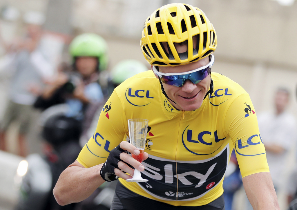 Britain's Chris Froome, wearing the overall leader's yellow jersey holds a glass during the twenty-first and last stage of the Tour de France cycling race over 103 kilometers (64 miles) with start in Montgeron and finish in Paris, France, Sunday, July 23, 2017. (Benoit Tessier, Pool via AP)