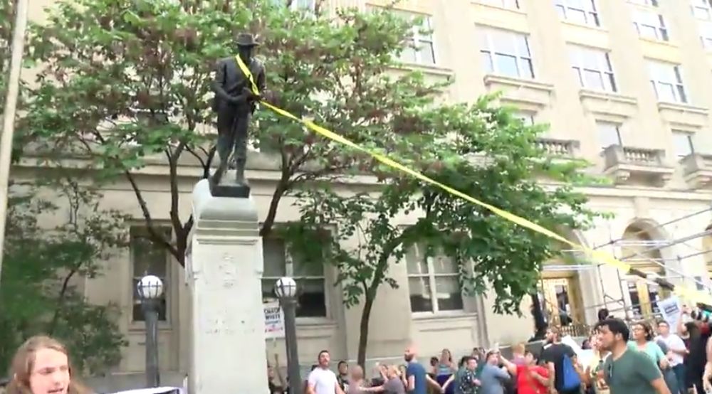 Après lui avoir noué une corde jaune autour du cou, la manifestante a poussé la statue déboulonnée, venue s'écraser lourdement au sol sous les cris de joie des assistants.