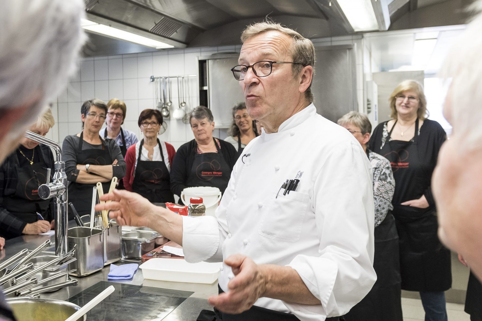 Georges Wenger, 18 points au Gault & Millau 2018, aime transmettre son amour de la cuisine, comme ici avec des bénévoles de Pro Senectute.