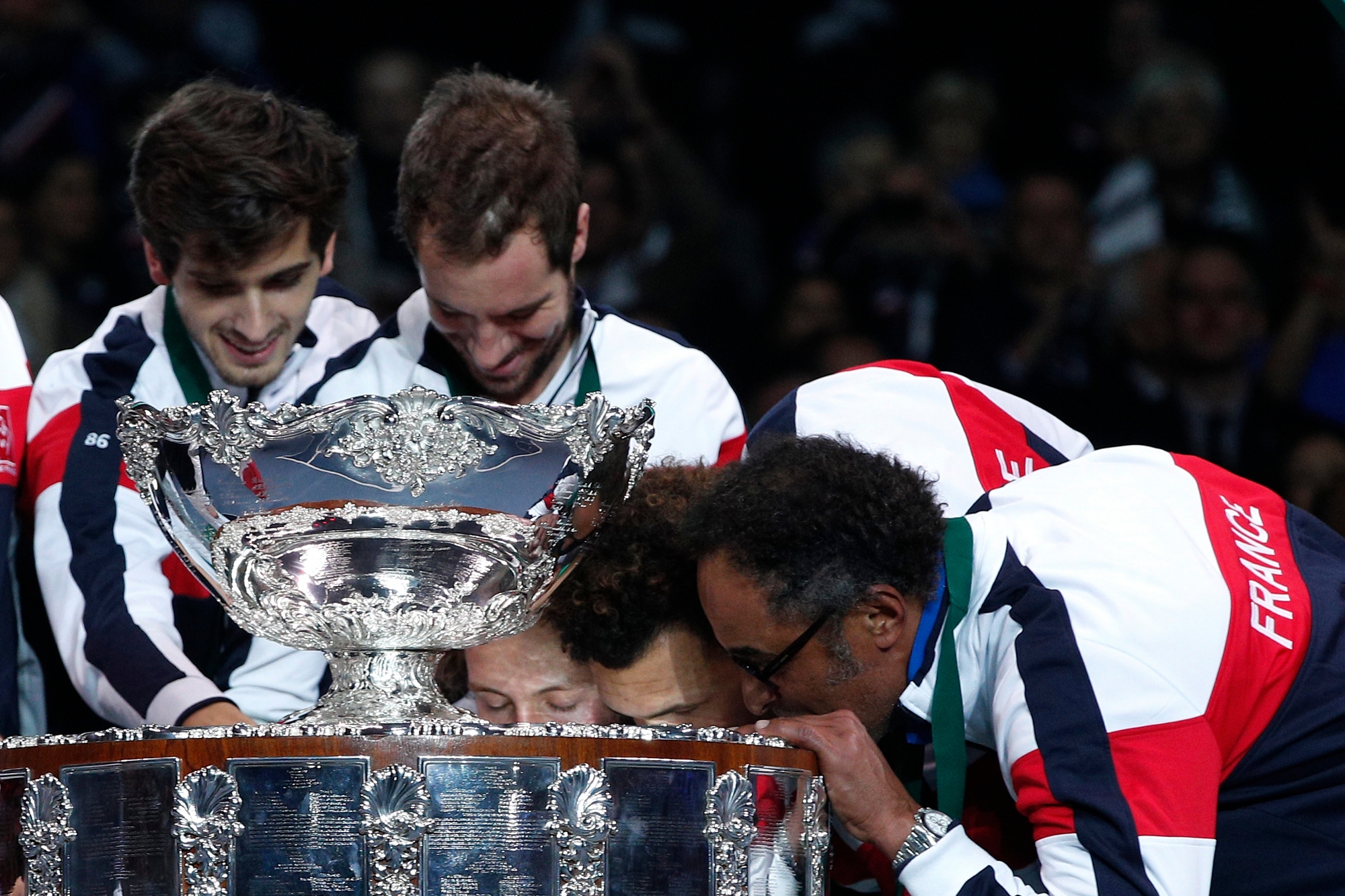 France's, from the right, Yannick Noah, Jo-Wilfired Tsonga, Richard Gasquet, second right, and Pierre-Hugues Herbert kiss and touch the cup after France won the Davis Cup at the Pierre Mauroy stadium in Lille, northern France, Sunday, Nov.26, 2017. France won the Davis Cup for the first time in 16 years after beating Belgium 3-2. (AP Photo/Christophe Ena) France Tennis Davis Cup Final