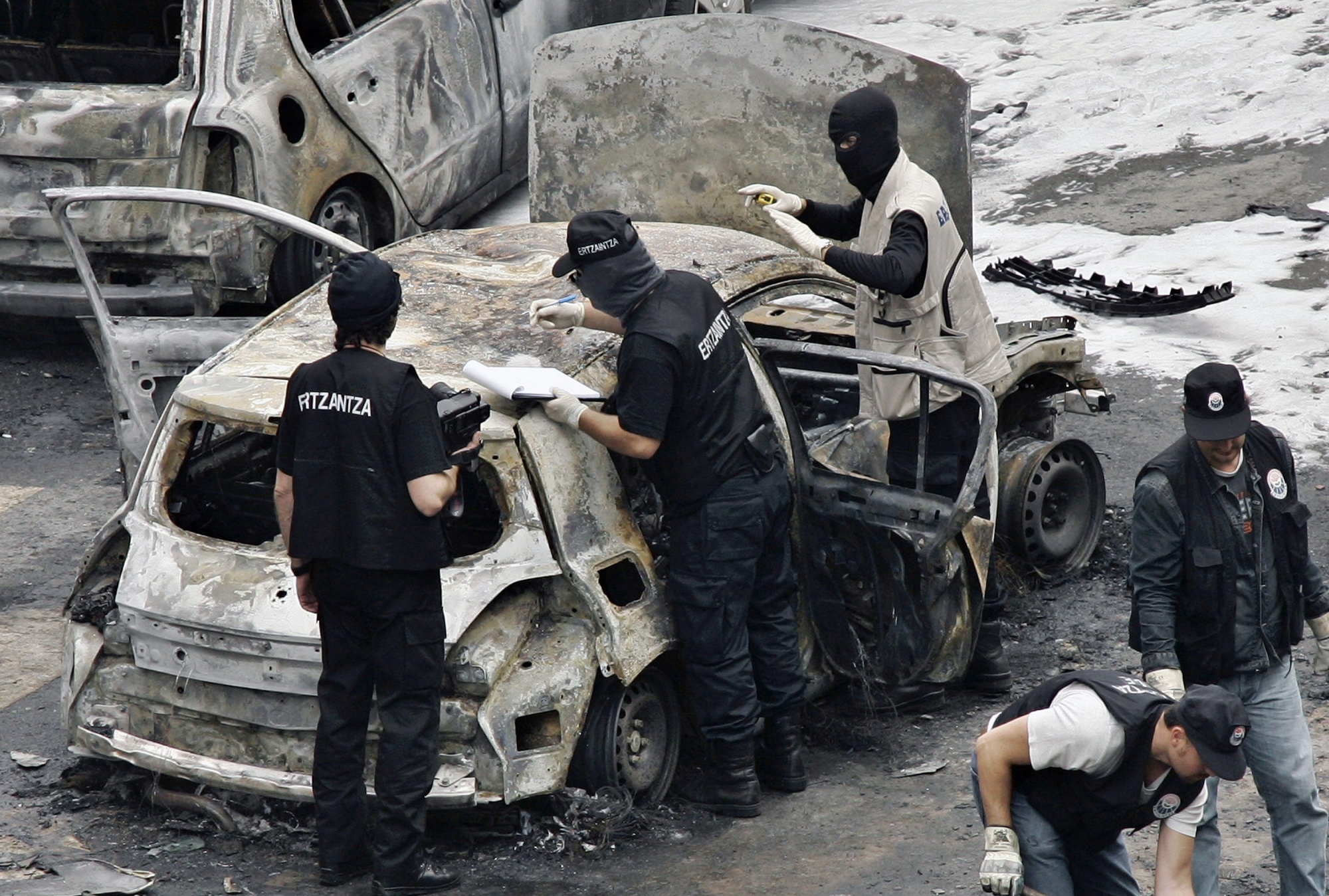 Police examine a car after it exploded in Bilbao, northern Spain, Tuesday Oct. 9, 2007. The bomb exploded in the Basque city of Bilbao, injuring a body guard assigned to a politician belonging to the Spanish prime minister's party, Basque regional police said. There was no immediate claim of responsibility but attention immediately focused on the separatist group ETA, which resumed full-scale attacks in August after calling off a cease-fire. (KEYSTONE/AP Photo/Alvaro Barrientos) SPAIN BOMBING