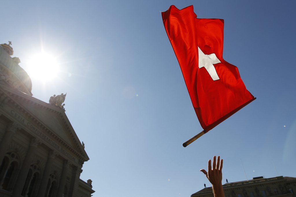 A flag thrower performs in front of the parliament building during the Familienfest on the Bundesplatz square, an election event of the rightist Swiss people's party (SVP), in Bern, Switzerland, Saturday, September 10, 2011. (KEYSTONE/Peter Klaunzer)