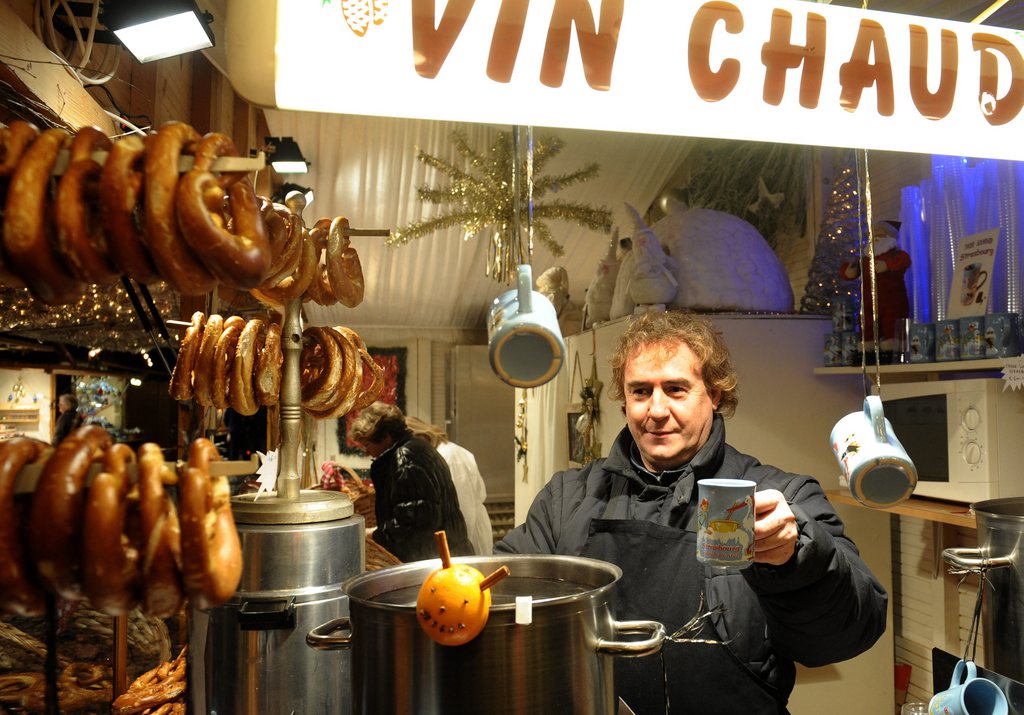 epa01950291 A vendor serves mulled wine to tourists at the traditional Christmas market, in Strasbourg, France, 30 November 2009. The eastern French Christmas market of Strasbourg is one of the oldest organised in Europe.  EPA/CHRISTOPHE KARABA