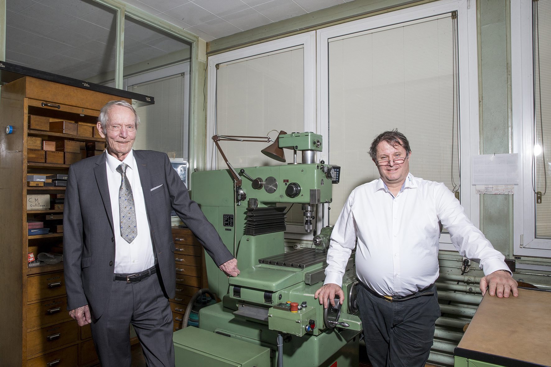 Claude et Laurent Giroud, devant la fameuse machine à pointer, acquise en 1969, qui a assuré la pérennité de l'entreprise.