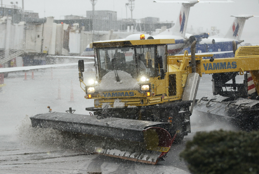 Grounds crews clear the tarmac at LaGuardia Airport in New York Friday, Feb. 8, 2013. Airlines scratched more than 3,700 flights in the Northeast through Saturday as snow began falling in what was predicted to be a huge blizzard that could dump 1 to 3 feet of snow from New York City to Boston and beyond. (AP Photo/Frank Franklin II)
