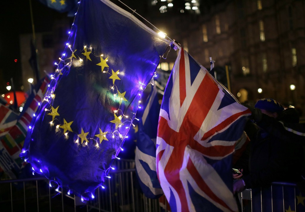 Anti-Brexit, remain in the European Union supporters hold an EU and British union flag outside the Houses of Parliament in London, Wednesday, March 13, 2019. Britain's Parliament will vote later Wednesday on whether to rule out leaving the EU on March 29 without a deal. (AP Photo/Tim Ireland)