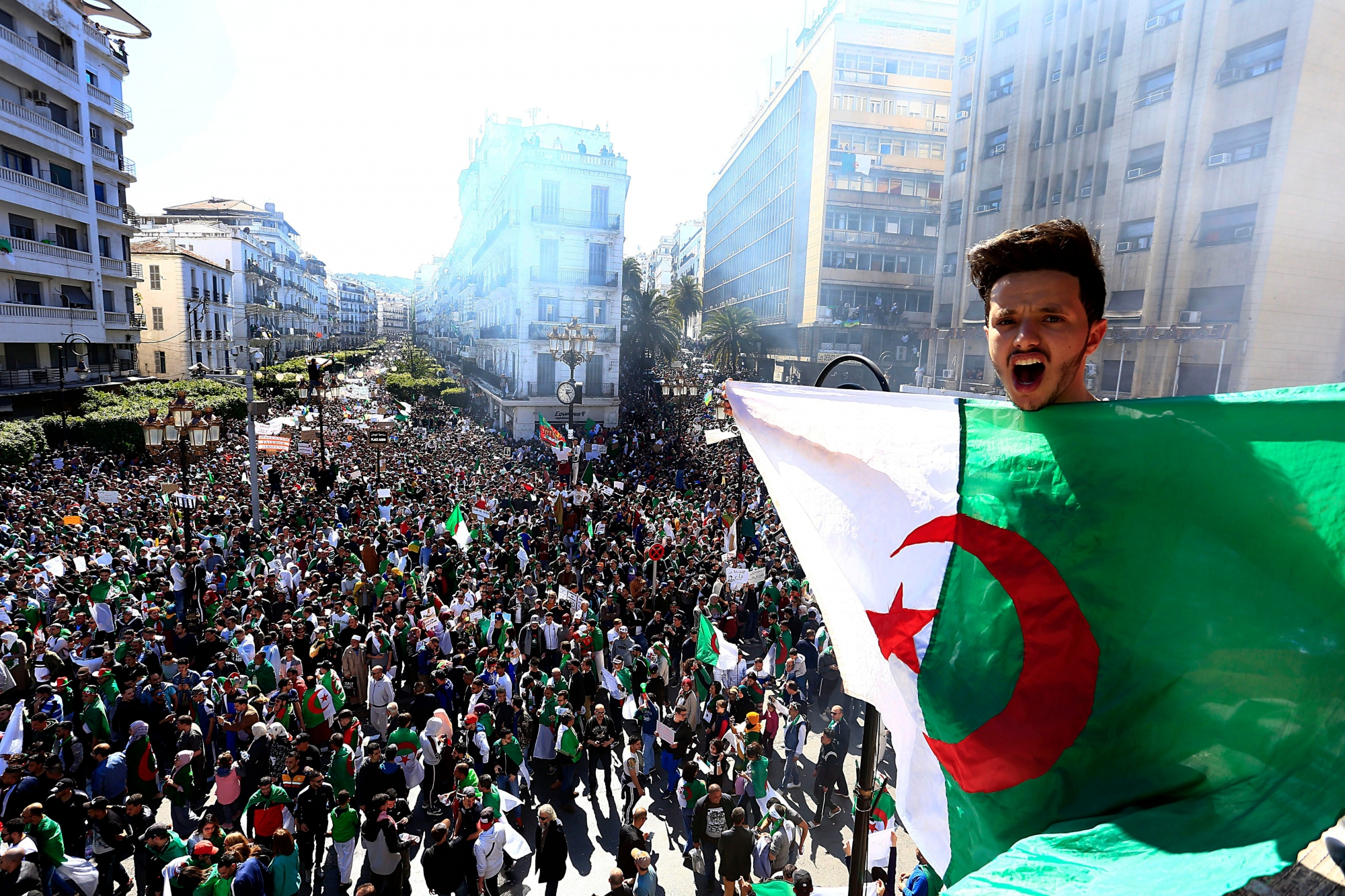 Algerian shouts as he holds the national flag during a protest in Algiers, Algeria, Friday, March 15, 2019. Tens of thousands of people gathered Friday in Algeria's capital and other cities amid heavy security for what could be decisive protests against longtime leader Abdelaziz Bouteflika. (AP Photo/Toufik Doudou) Algeria Protests