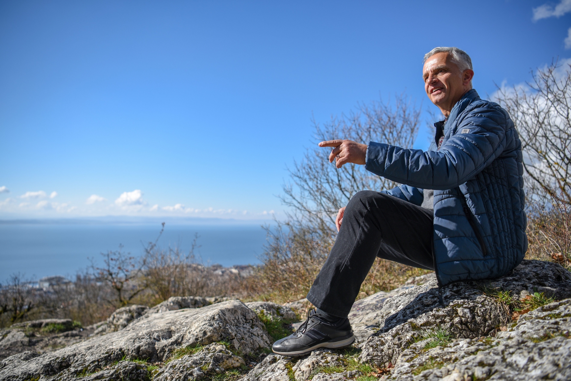 Didier Burkhalter assis sur son caillou favori, au Rocher de l'Ermitage qui surplombe la ville de Neuchâtel. "Je ne me lasse pas de cette vue", lâche-t-il.