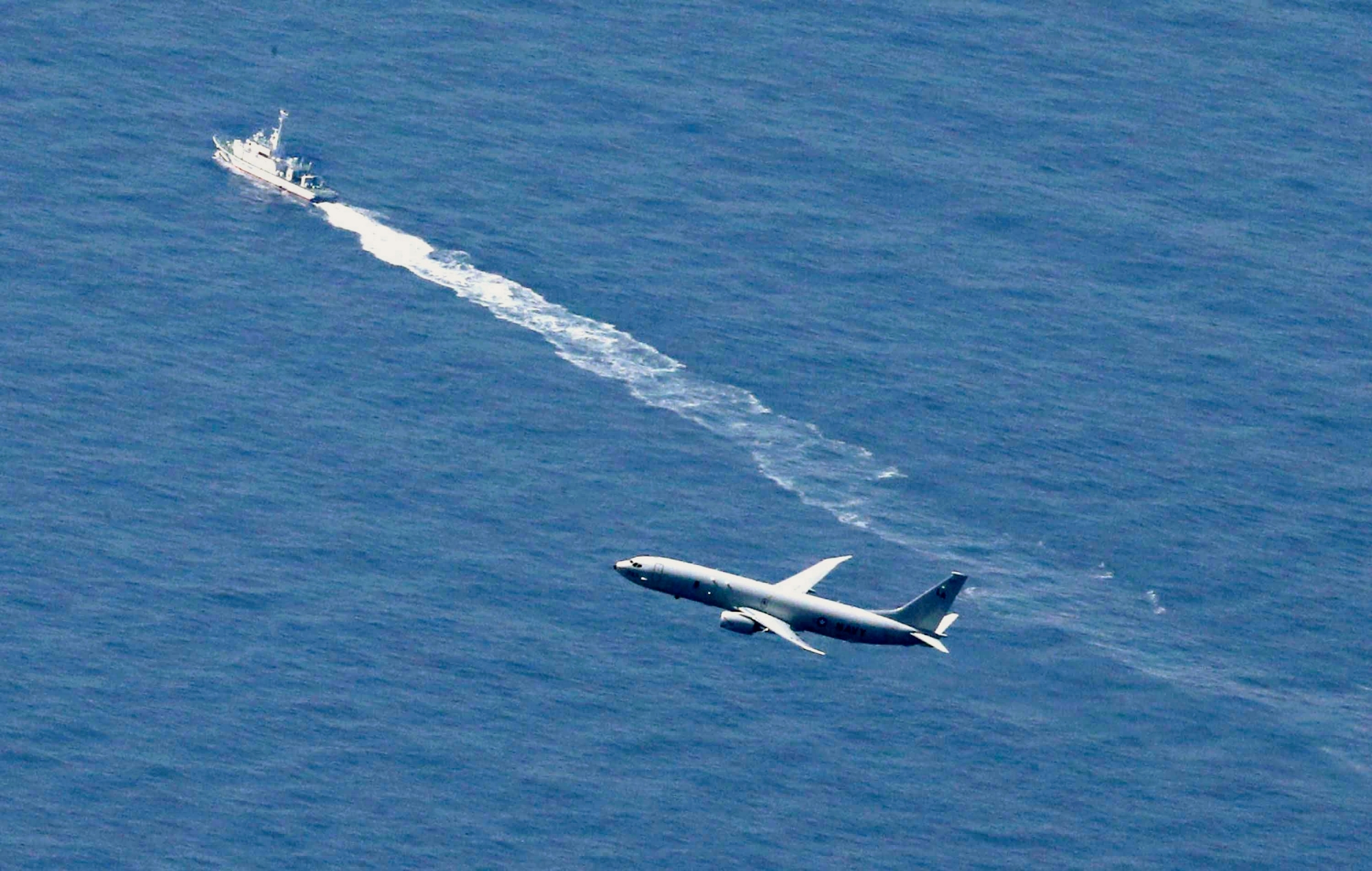 A Japan Coast Guard's vessel and U.S. military plane search for a Japanese fighter jet, in the waters off Aomori, northern Japan, Wednesday, April 10, 2019. The Japanese air force F-35 stealth fighter crashed into the Pacific Ocean during a night training flight and parts of the jet were recovered, the defense ministry said Wednesday. (Kyodo News via AP) Japan Fighter Jet