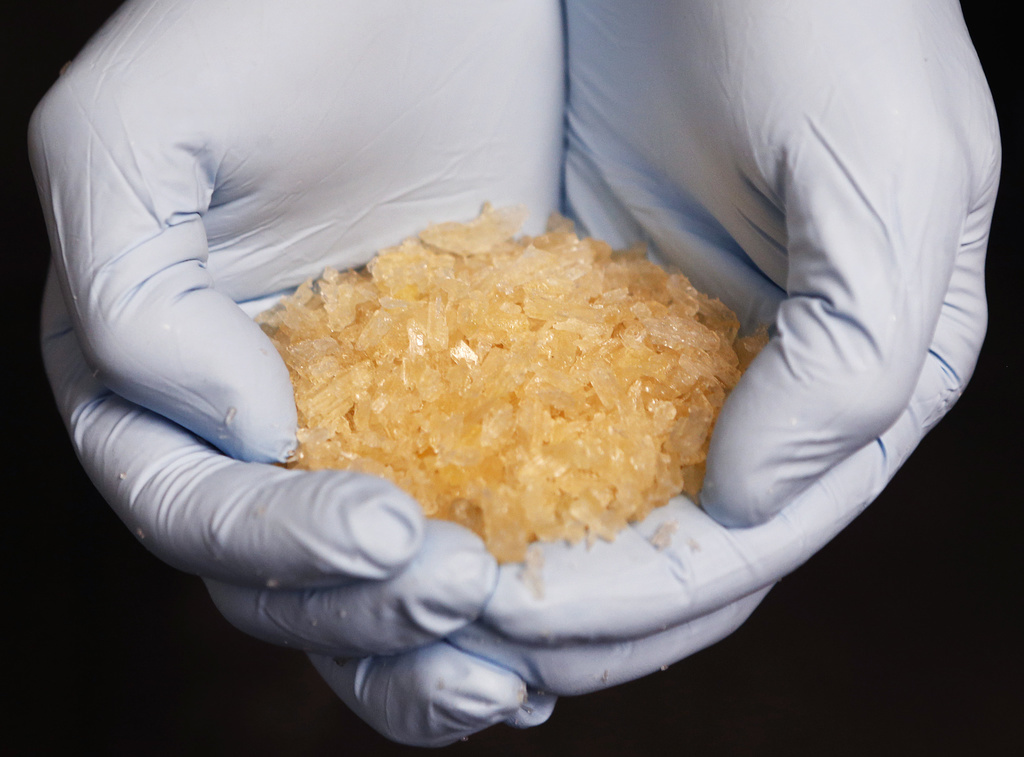 A criminal expert shows Crystal meth at the German federal police in Wiesbaden, Germany, Thursday, Nov.13, 2014. Authorities have seized 2.9 tons of a chemical used to produce crystal meth in an operation that brought 15 arrests in Germany and the Czech Republic, German police said Thursday. The chloroephedrine seized in the eastern German city of Leipzig last week could have been used to produce 2.3 tons of crystal meth with an estimated street value of 184 million euros (US $230 million), the Federal Criminal Police Office said. (AP Photo/Michael Probst)