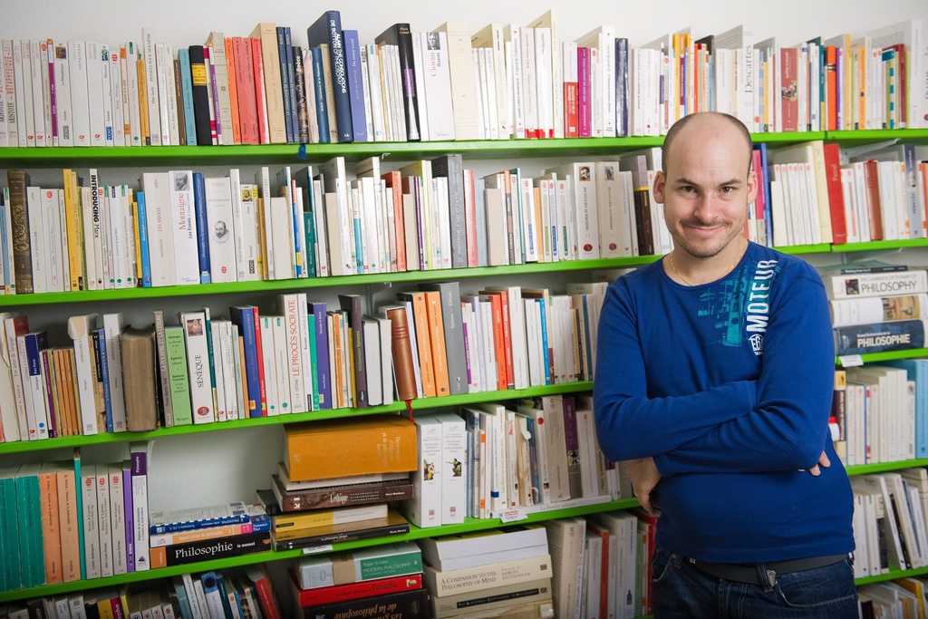 Alexandre Jollien, philosophe et ecrivain, pose devant sa bibliotheque a l'occasion de la sortie de son dernier livre, "Le philosophe nu" ce mercredi 8 aout 2010 a Lausanne. (KEYSTONE/Jean-Christophe Bott)