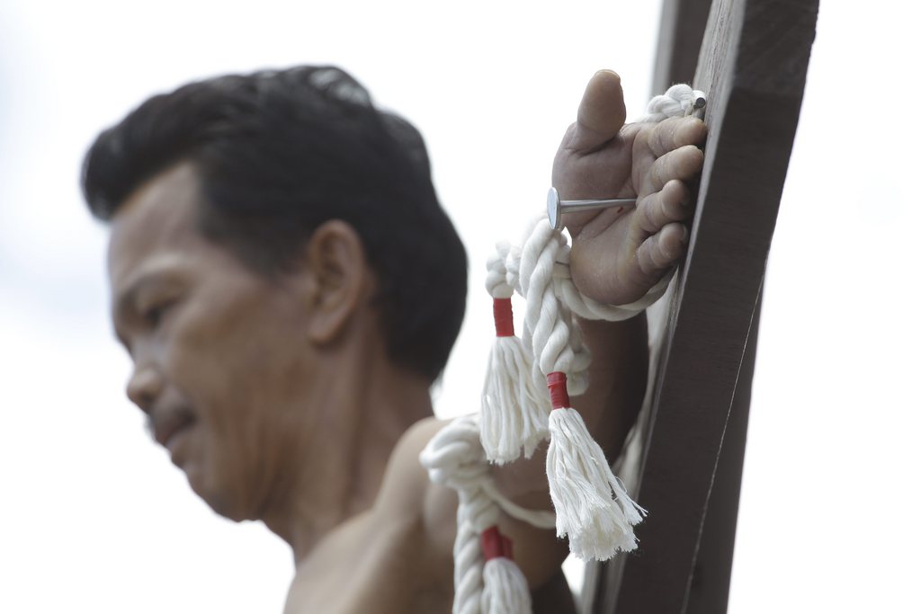 A Filipino penitent is nailed to the cross during Good Friday rituals Friday, March 29, 2013 in Cutud, Pampanga province, northern Philippines. Several Filipino devotees had themselves nailed to crosses Friday to remember Jesus Christ's suffering and death, an annual rite rejected by church leaders in this predominantly Roman Catholic country. (AP Photo/Aaron Favila)