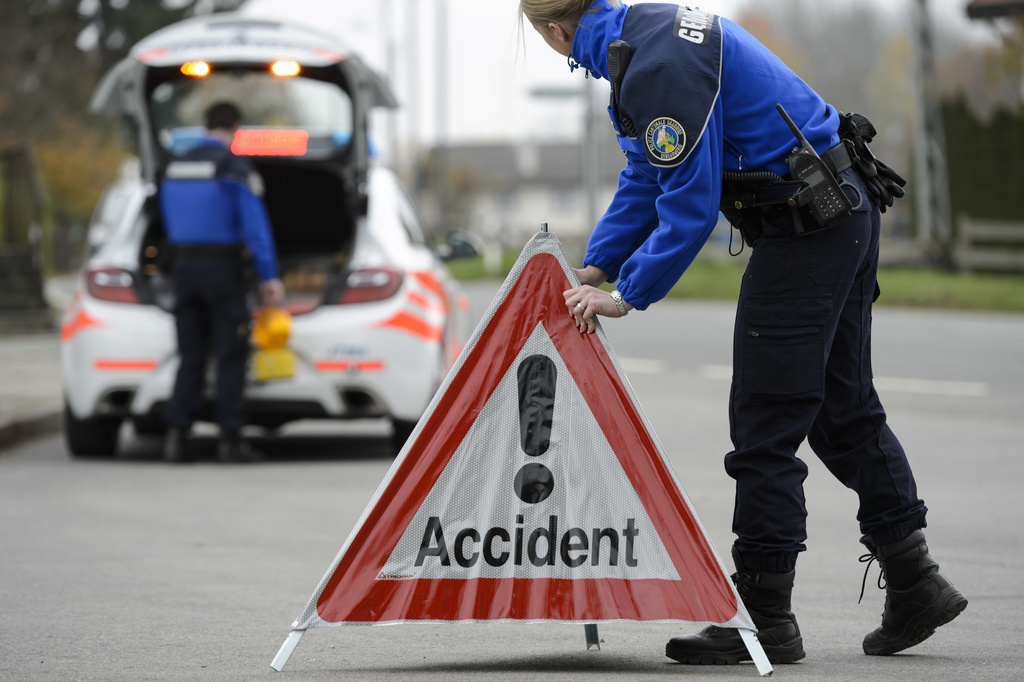 [Editor's note: photo mise-en-scene] A police officer from the cantonal police of Vaud installs a police warning triangle, in the foreground, while another officer stands next to a police car, in the background, photographed in Cugy, in the Canton of Vaud, Switzerland, on November 3, 2015. (KEYSTONE/Laurent Gillieron)  [Editor's note: photo mise-en-scene] Une patrouille de policier (gendarme) du corps de gendarmerie de la Police cantonale vaudoise place un panneau accident proche d'une voiture de police ce mardi 3 novembre 2015 a Cugy, Vaud. (KEYSTONE/Laurent Gillieron)