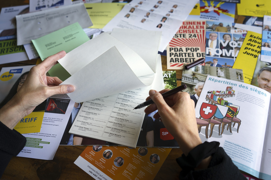 Eine Frau schaut die Wahlzettel fuer die Nationalratswahlen 2019 durch, am Montag 7, Oktober 2019, in Bern. (KEYSTONE/Anthony Anex)