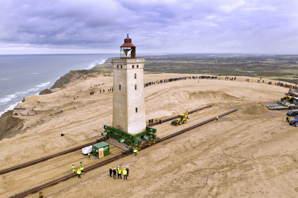 The Rubjerg Knude Lighthouse is being moved on tracks in Jutland, Denmark, Tuesday, Oct. 22, 2019. A 120-year-old lighthouse has been put on wheels and rails to attempt to move it some 80 meters (263 feet) away from the North Sea, which has been eroding the coastline of northwestern Denmark. When the 23-meter (76 feet) tall Rubjerg Knude lighthouse was first lit, in 1990, it was roughly 200 meters (656 feet) from the coast; now it is only about 6 meters away. (Hans Ravnr/Ritzau Scanpix via AP)