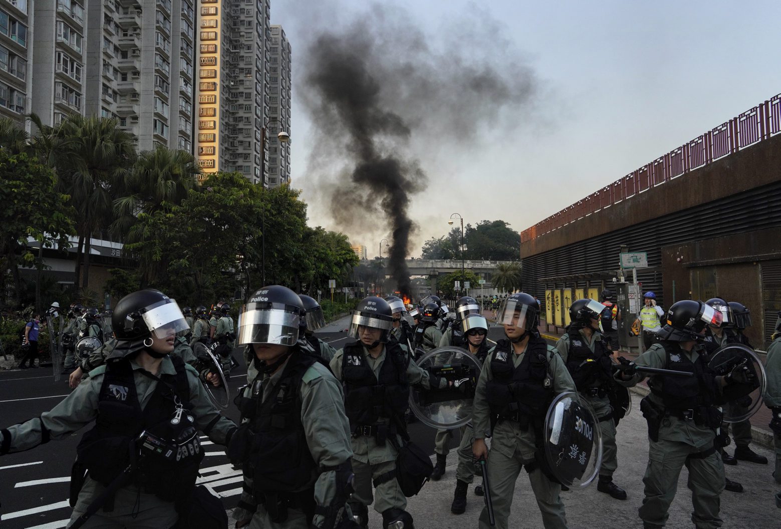 Riot police march past a burning barricade during a protest in Hong Kong on Sunday, Sept. 22, 2019. Hong Kong's pro-democracy protests, now in their fourth month, have often descended into violence late in the day and at night. A hardcore group of protesters says the extreme actions are needed to get the government's attention. (AP Photo/Vincent Yu) Hong Kong Protests