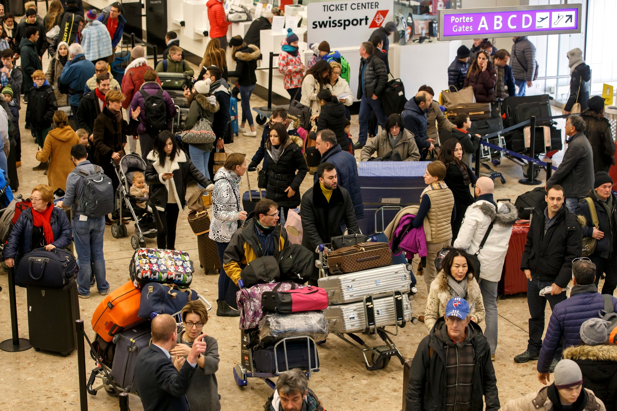 Flight passengers arrive in the check-in area, at the Geneva Airport, in Geneva, Switzerland, Sunday, January 8, 2017. Thousands of skiers and travelers are expected at the airport after celebrating Christmas and New Year for returning in their countries. (KEYSTONE/Salvatore Di Nolfi) SWITZERLAND FEATURE AIRPORT GENEVA