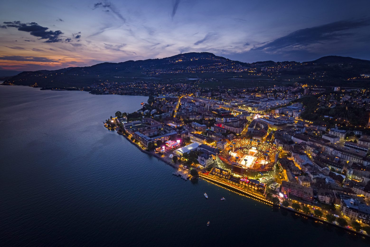 An aerial view shows the full arena of the "Fete des Vignerons" (winegrowers' festival in French), with a capacity of 20'000 spectators and hosting a giant central LED floor of approximately 800 square meters, during the opening night in Vevey, Switzerland, Thursday, July 18, 2019. Organized in Vevey by the brotherhood of winegrowers since 1979, the event will celebrate winemaking from July 18 to August 11 this year. (KEYSTONE/Valentin Flauraud). Une vue aerienne montre l'arene de la Fete des Vignerons (FEVI) et son sol en LED geant d'approximativement 800 metres carres pendant le premier spectacle ce jeudi 18 juillet 2019 a Vevey. (KEYSTONE/Valentin Flauraud) SWITZERLAND FETE DES VIGNERONS REHEARSAL