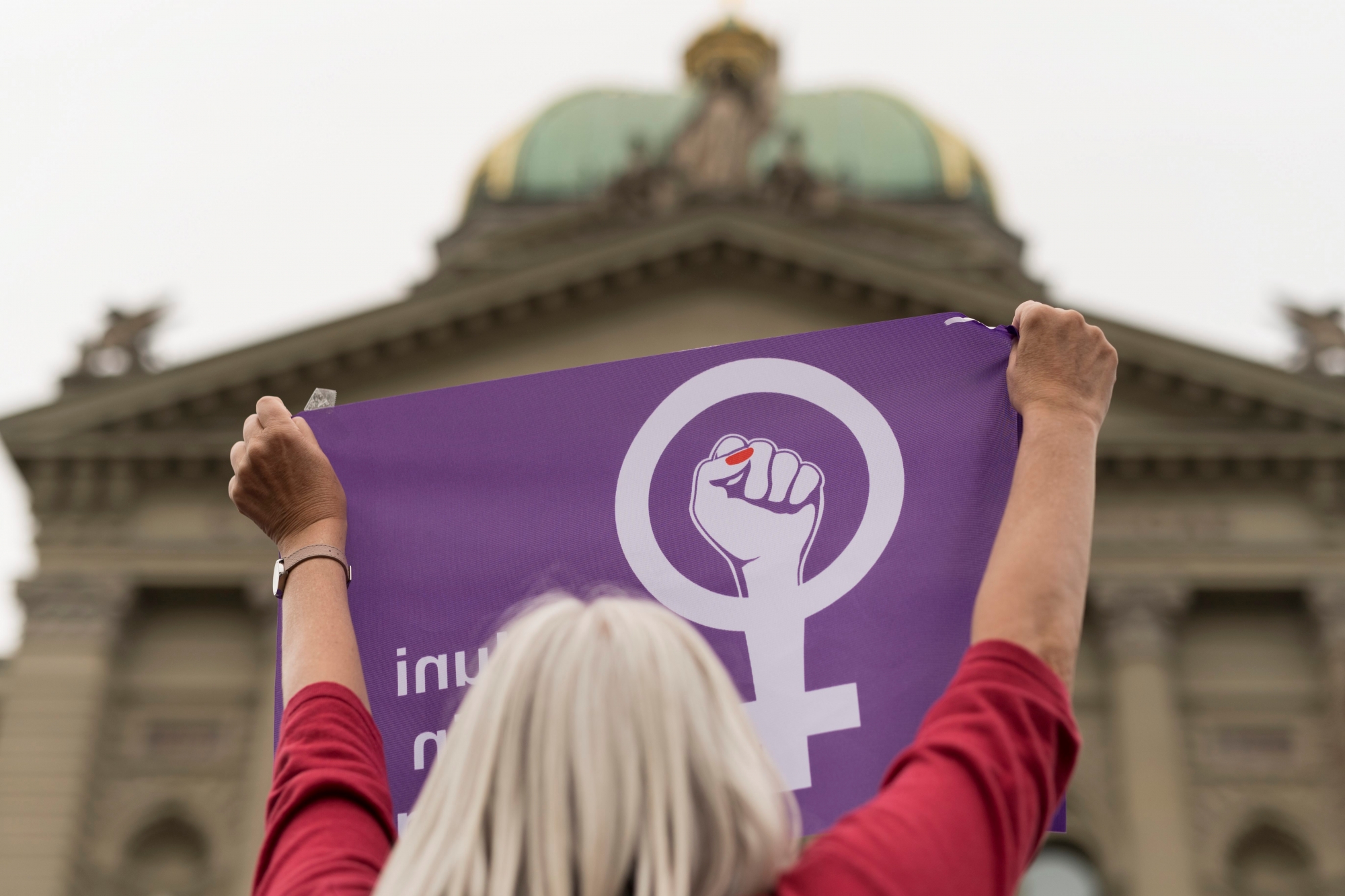 Eine Frau schwingt die Fahne des Frauenstreiks vor dem Bundeshaus, am Freitag, 14. Juni 2019 in Bern. (KEYSTONE/Alessandro della Valle) SCHWEIZ FRAUENSTREIK GROSSKUNDGEBUNGEN