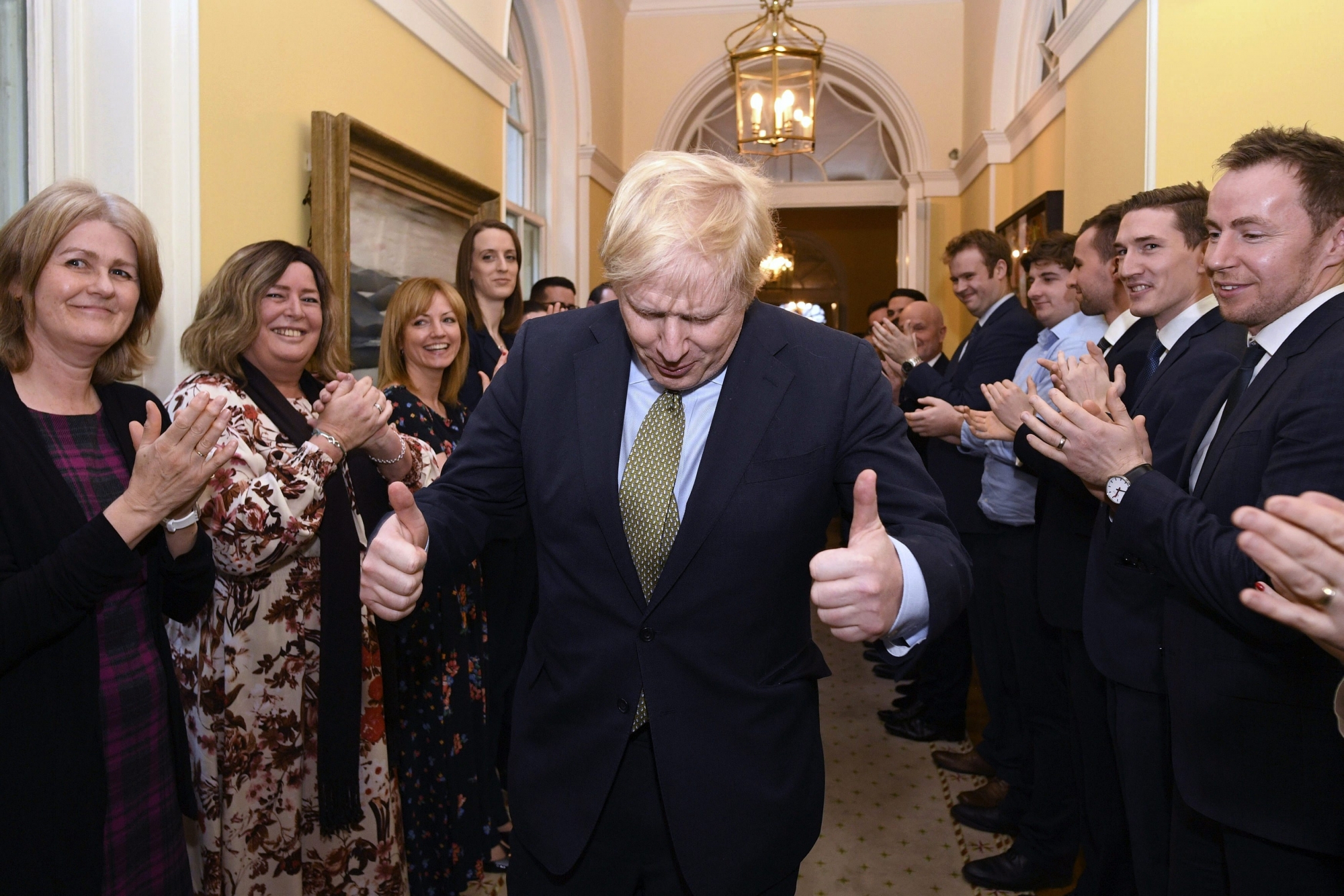 Britain's Prime Minister Boris Johnson is greeted by staff as he returns to 10 Downing Street, London, after meeting Queen Elizabeth II at Buckingham Palace and accepting her invitation to form a new government, Friday Dec. 13, 2019.  Boris Johnson led his Conservative Party to a landslide victory in BritainÄôs election that was dominated by Brexit. (Stefan Rousseau/PA via AP) Britain Brexit Election