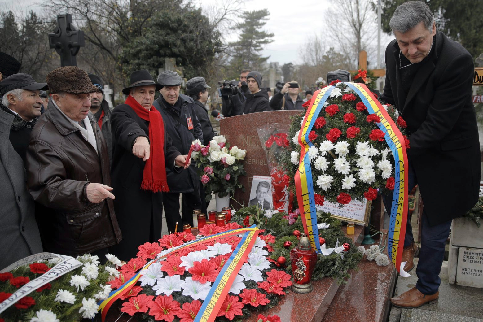 A man places a wreath at Romanian communist dictator Nicolae Ceausescu's grave, as communism nostalgics gather in Bucharest, Romania, Wednesday, Dec. 25, 2019, 30 years after he and his wife Elena were executed by firing squad on Christmas day 1989. Romania marks the 30th anniversary of the anti-communist uprising which started in the western Romanian town of Timisoara on Dec. 16 and in Bucharest on Dec. 21, 1989, left more than one thousand people dead and ended the rule of dictator Nicolae Ceausescu. (AP Photo/Vadim Ghirda) Romania Ceausescu Revolution 30th Anniversary