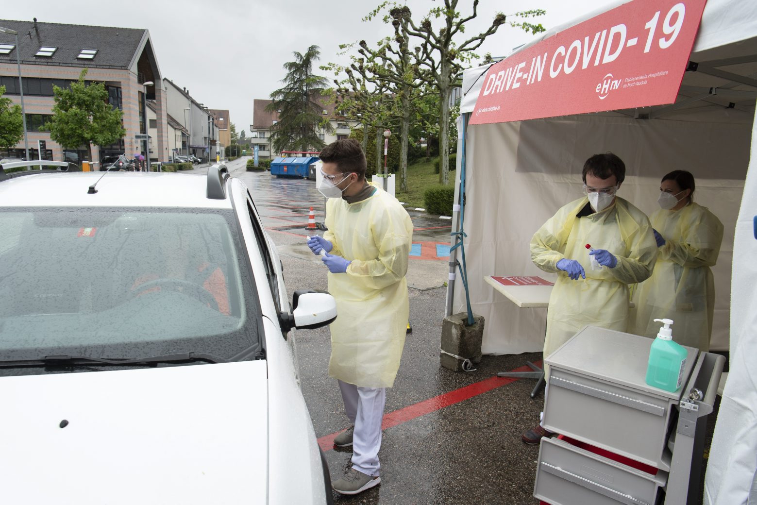 Medical workers take a swab at a drive-in coronavirus testing facility in front of the eHnv hospital eHnv "Etablissements Hospitaliers du Nord Vaudois" during the state of emergency of the coronavirus disease (COVID-19) outbreak, in Yverdon-les-bains, Switzerland, Thursday, April 30, 2020. Countries around the world are taking increased measures to stem the widespread of the SARS-CoV-2 coronavirus which causes the Covid-19 disease. (KEYSTONE/Laurent Gillieron) SWITZERLAND CORONAVIRUS OUTBREAK