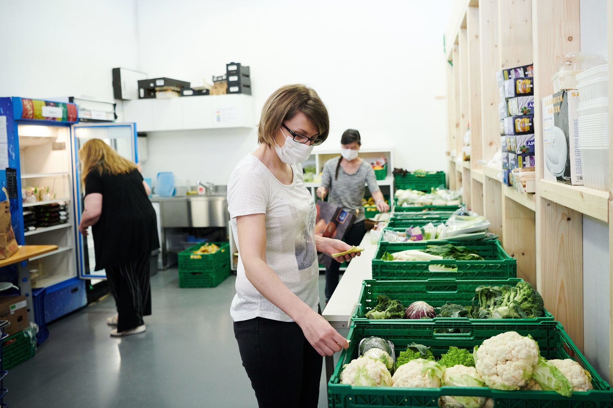 Yolande Liechti, l'une des responsables de l'association Un jour sans faim, avec un masque, en train de préparer un lot de légumes invendus.
