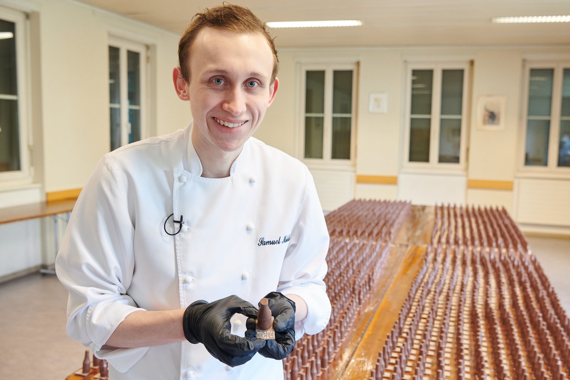 Samuel Müller avec l'une des 3000 petites bouteilles en chocolat qu'il a préparées.